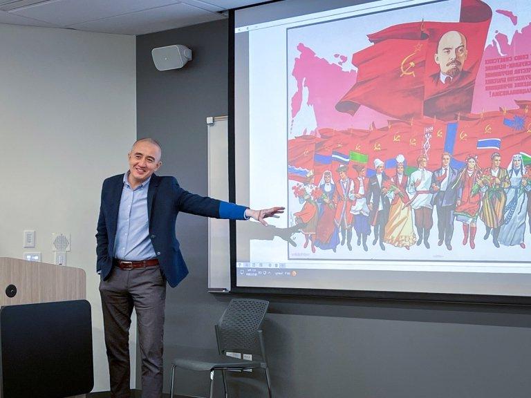 Azamat Junisbai points to a Soviet painting during a fall 2024 presentation